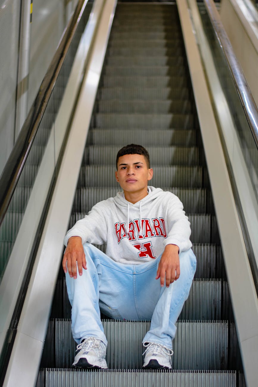 teenage boy sitting on the escalator