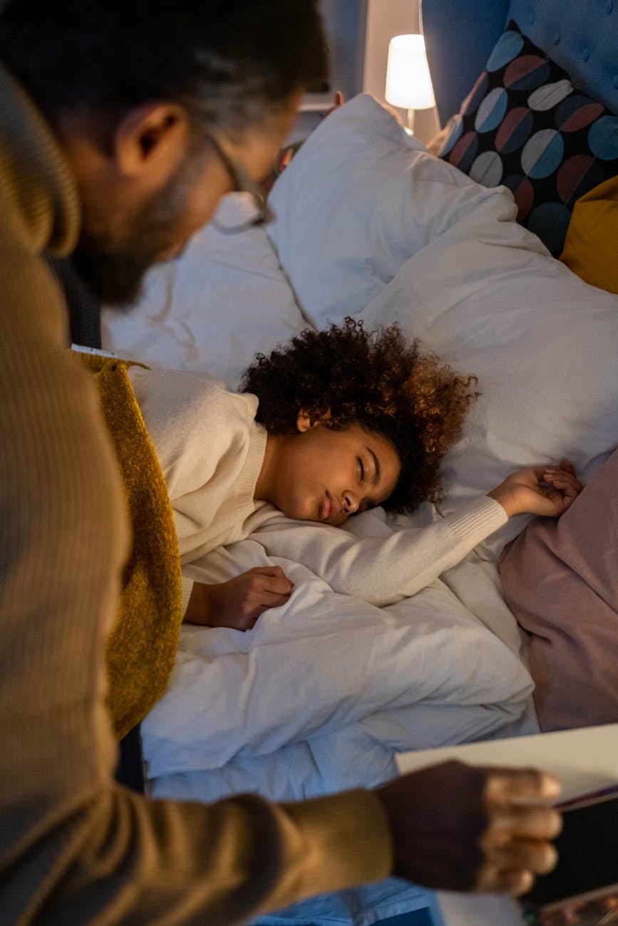 a father looking at the sleeping daughter